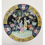 Early 20th century Chinese famille noir charger, decorated with two ladies in a garden before