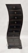 Modern ebonised chest of nine short drawers of upright serpentine design, 131cm high x 50cm wide x
