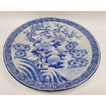 Large Japanese blue and white porcelain charger, circa 1900, painted with flowers, prunus and a bird