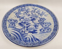 Large Japanese blue and white porcelain charger, circa 1900, painted with flowers, prunus and a bird