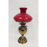 Early 20th century gilt metal and opaque glass mounted oil lamp, with opaque red glass shade,