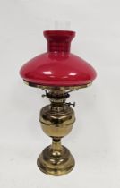 Early 20th century gilt metal and opaque glass mounted oil lamp, with opaque red glass shade,