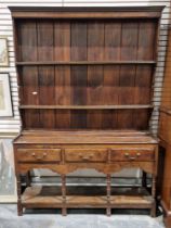 18th century oak dresser with three-tier plate rack over three short drawers, each with brass