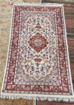 Indian cream ground wool pile rug, central floral medallion within stylised floral panel with