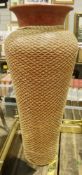 Large floor-standing terracotta vase with woven net covering