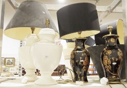 Pair of urn-shaped white glazed lamps and a pair of black and gold vase-style lamps with gold floral