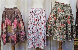 Three 1950's full circle skirts, two cotton with bright print, a stiffened felt full circle skirt