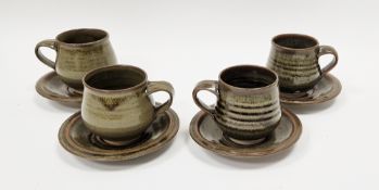 Set of four studio pottery stoneware cups and saucers with tenmoku glaze, indistinct mark.