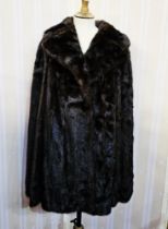 Dark mink cape lined in satin, labelled 'Revillon, Paris, New York', with leather belt which would