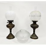 Two Victorian brass oil lamps with chimneys, one floral etched shade, the other white opaque