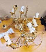 Three contemporary gilt-metal five-light pendant lights, of traditional form, suspending swags, with