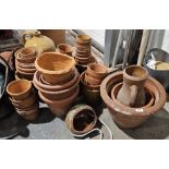 Extensive collection of small and medium terracotta pots to include hanging examples, wall