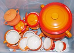 Collection of orange glazed ceramic Le Creuset, to include casserole pots, bean pots and ramekins