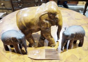 Large carved wooden elephant and two smaller wooden elephants, and a wooden carved comb (1 box)