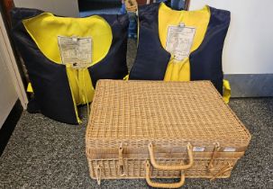 Two Regatta life jackets within a wicker picnic basket