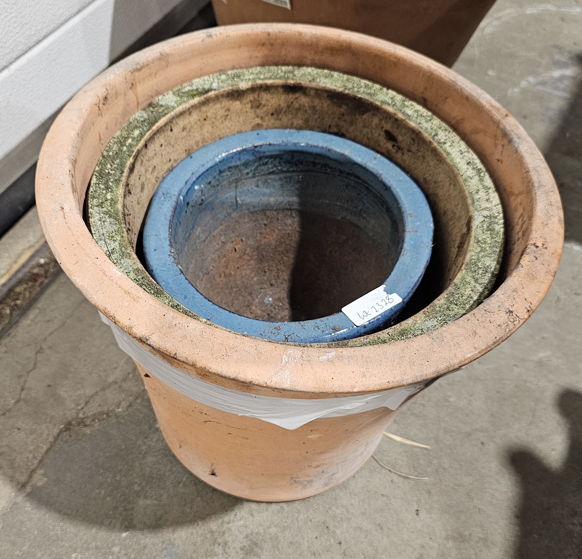 Three terracotta flower pots in sizes, including a blue glazed example, 28cm high max. (3)