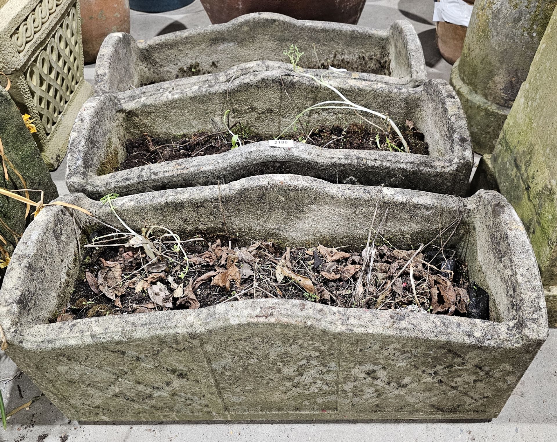 Three rectangular composite stone planters decorated with lattice panels with a central panel