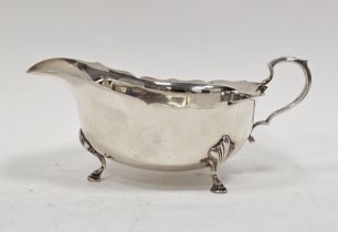 Georgian-style silver sauceboat of typical oval form with everted ogee cut-card borders and raised