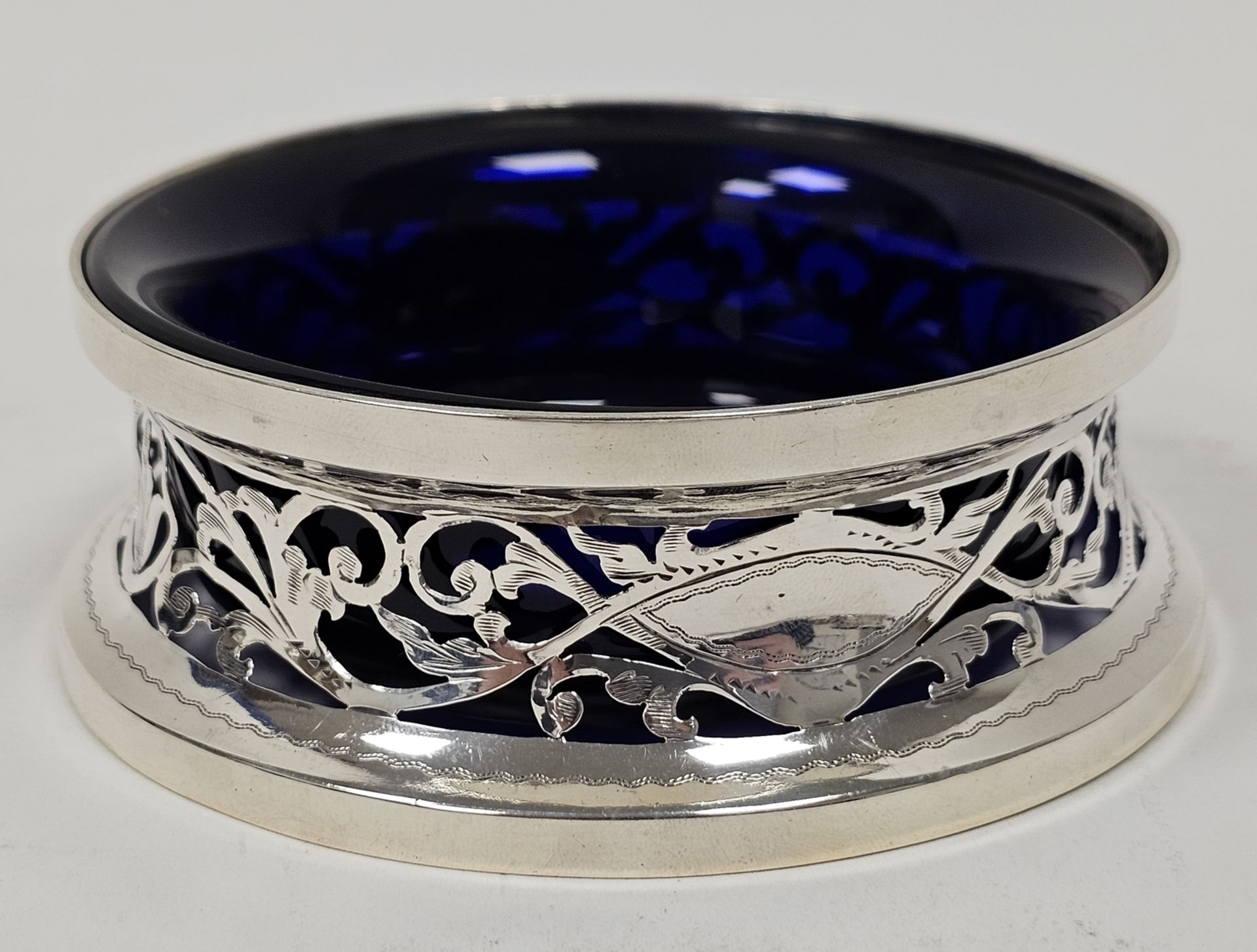 George V silver miniature dish ring of typical waisted form and pierced with foliate scrolls and two - Image 3 of 4