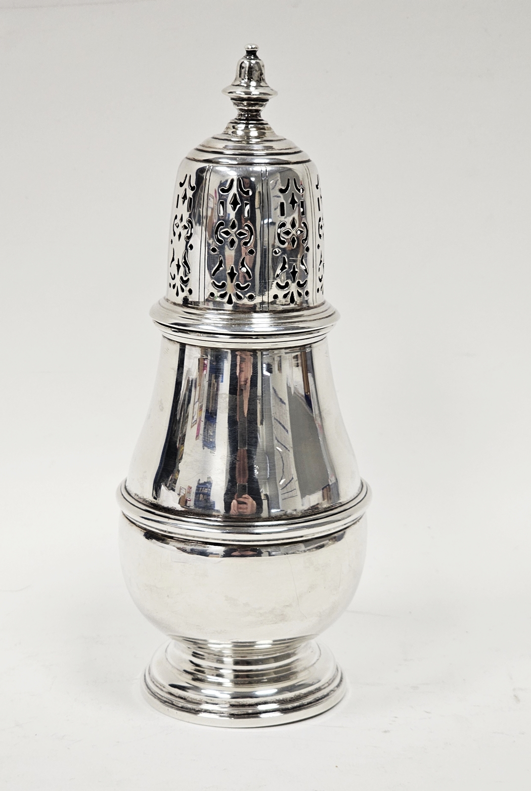 A George VI silver baluster shape sugar caster, the pierced detachable cover with knop finial, the