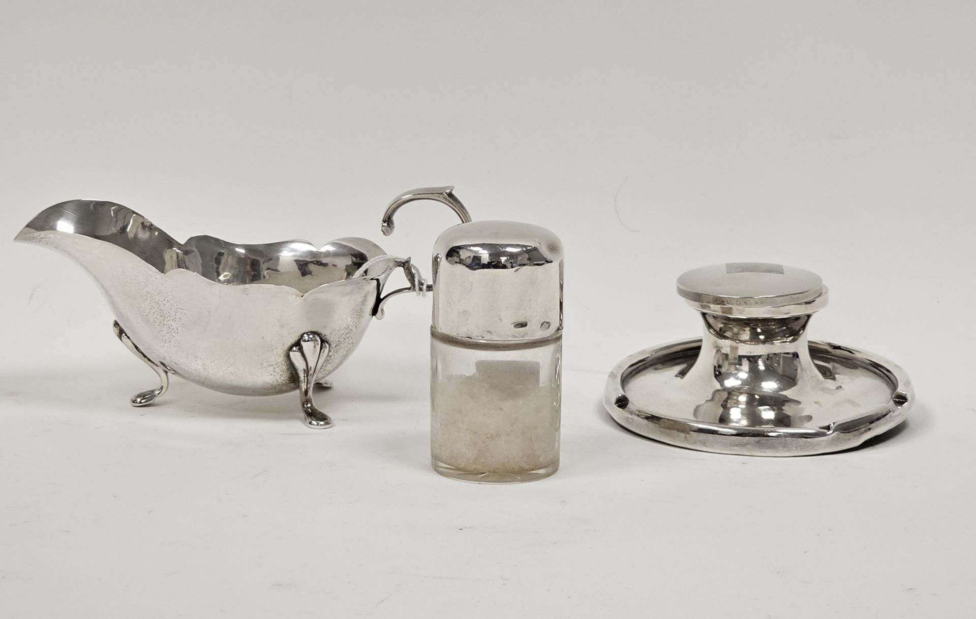 An Edwardian silver cream jug, of plain form, scalloped edge, raised on three pad feet, scroll