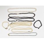 Three strings of grey/black pearls, similar bracelet, white cultured pearl necklace, two strings