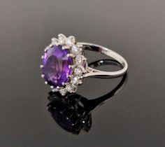 18ct gold, amethyst and diamond cluster ring, the oval amethyst 11.9mm x 9.9mm x 6.4mm deep