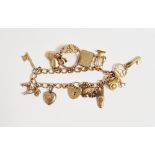9ct gold oval loop charm bracelet with padlock clasp and multiple charms including scales and