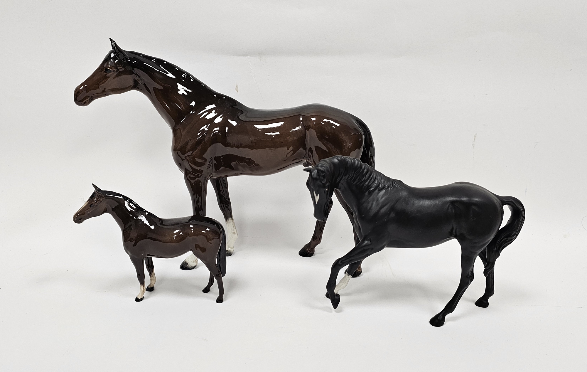 Three Beswick pottery models of horses comprising a large chestnut coloured horse, 35cm long,