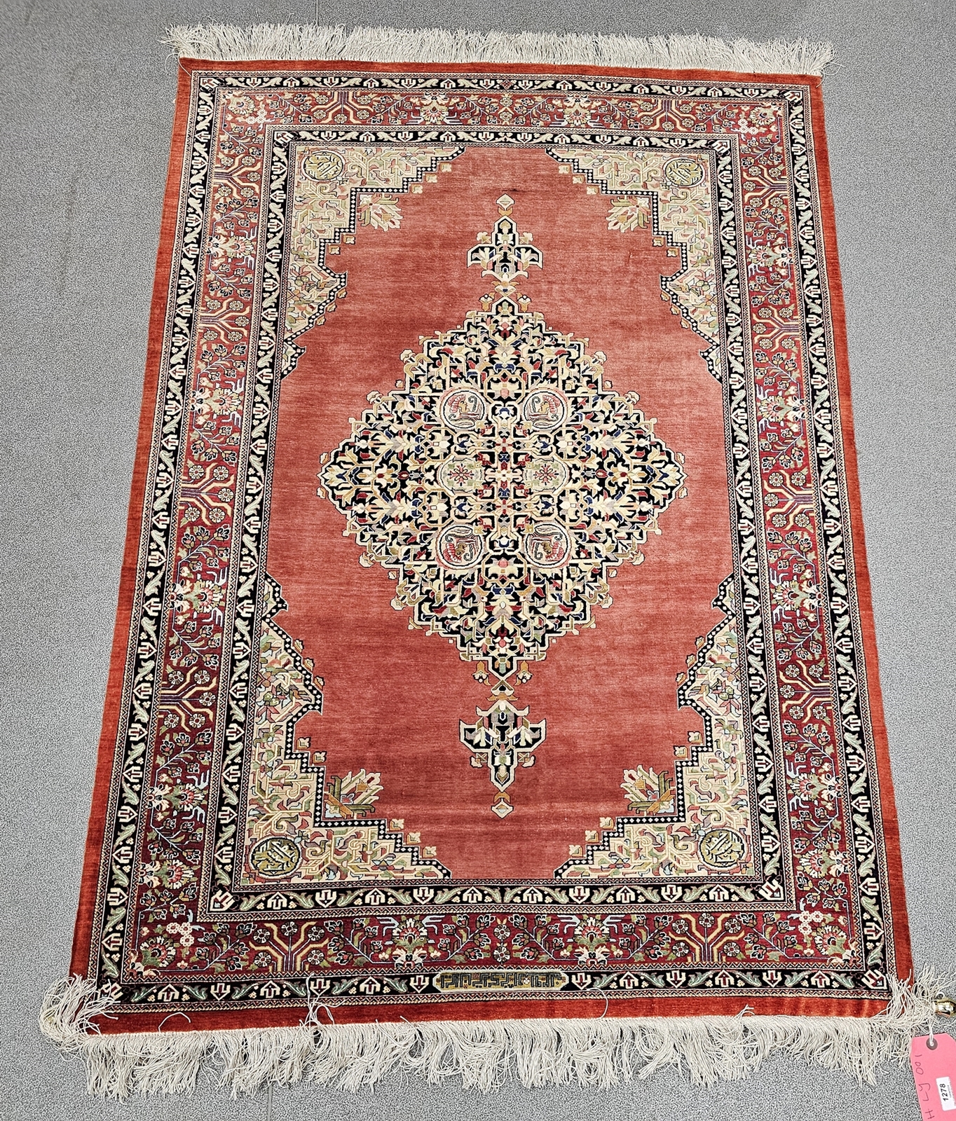 Eastern red ground silk rug, possibly Iraq, the central lozenge medallion depicting flowers and