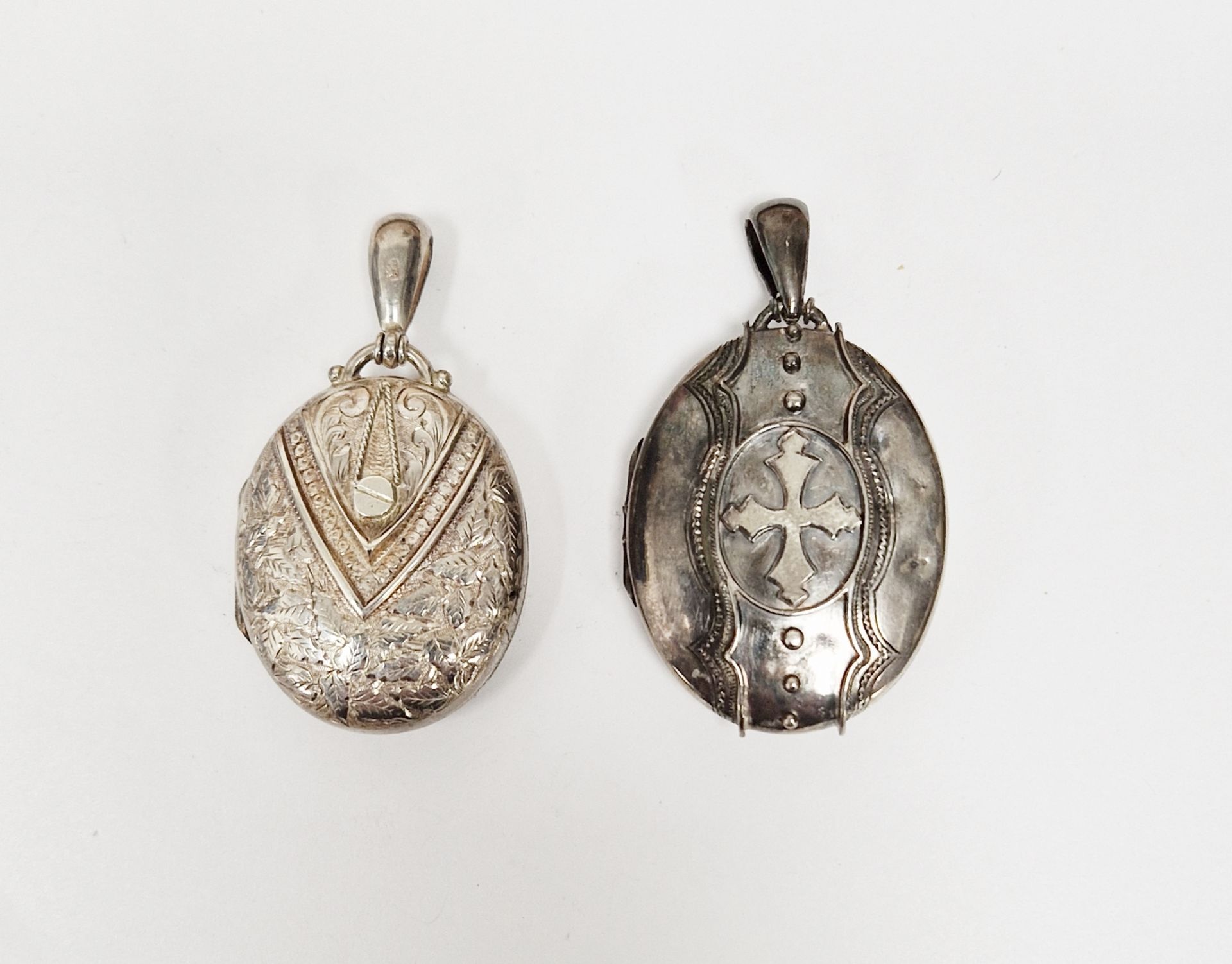 Victorian silver locket, oval and engraved and another similar with cross design to the front