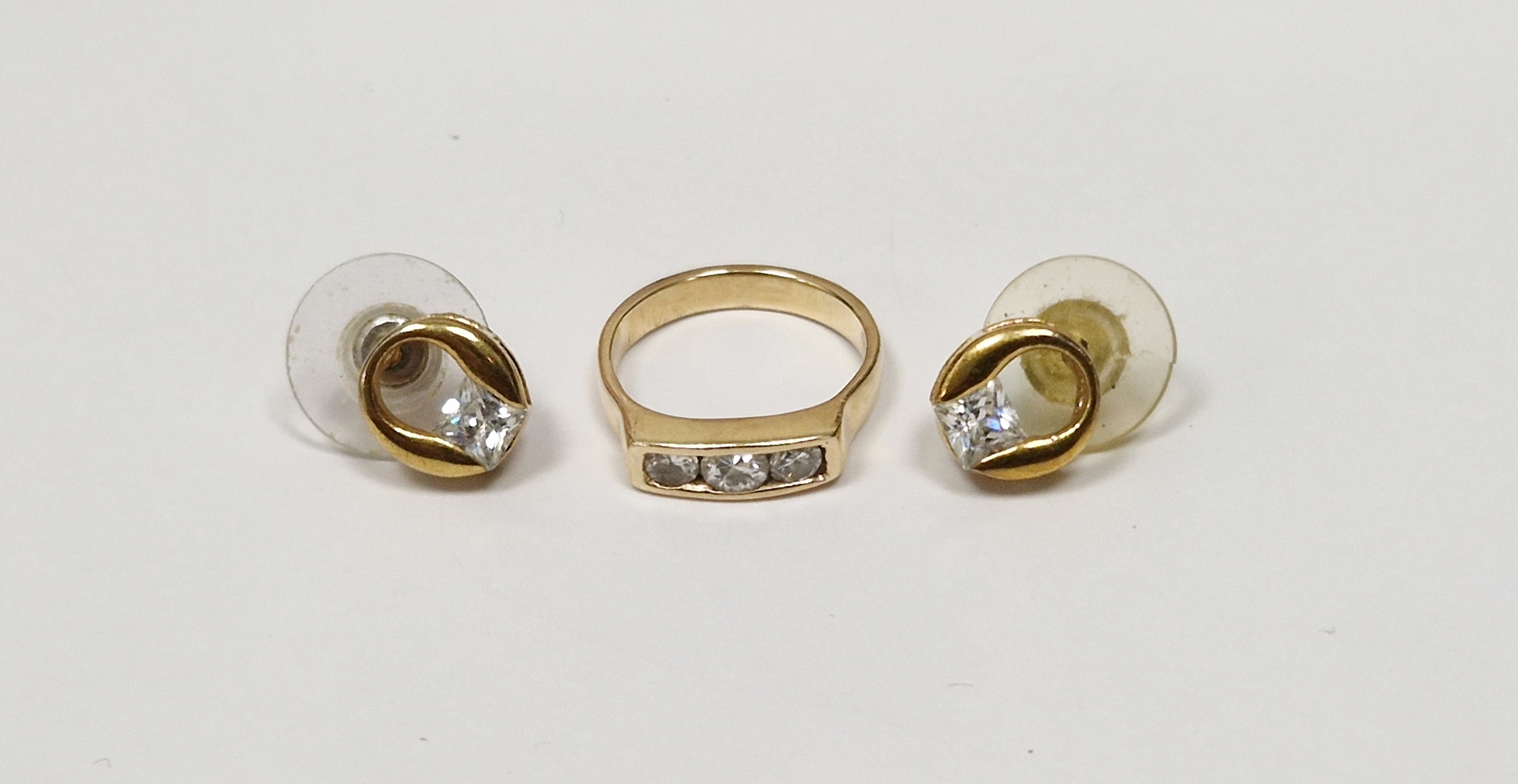 Gold-coloured and diamond three-stone ring, unmarked and a pair of gold-coloured and paste solitaire