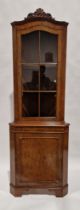 Reproduction yew veneer standing corner cupboard with carved pediment over a single glazed