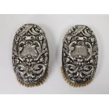 Pair of Victorian silver backed oval clothes brushes, each in repousse with masks and scrolling