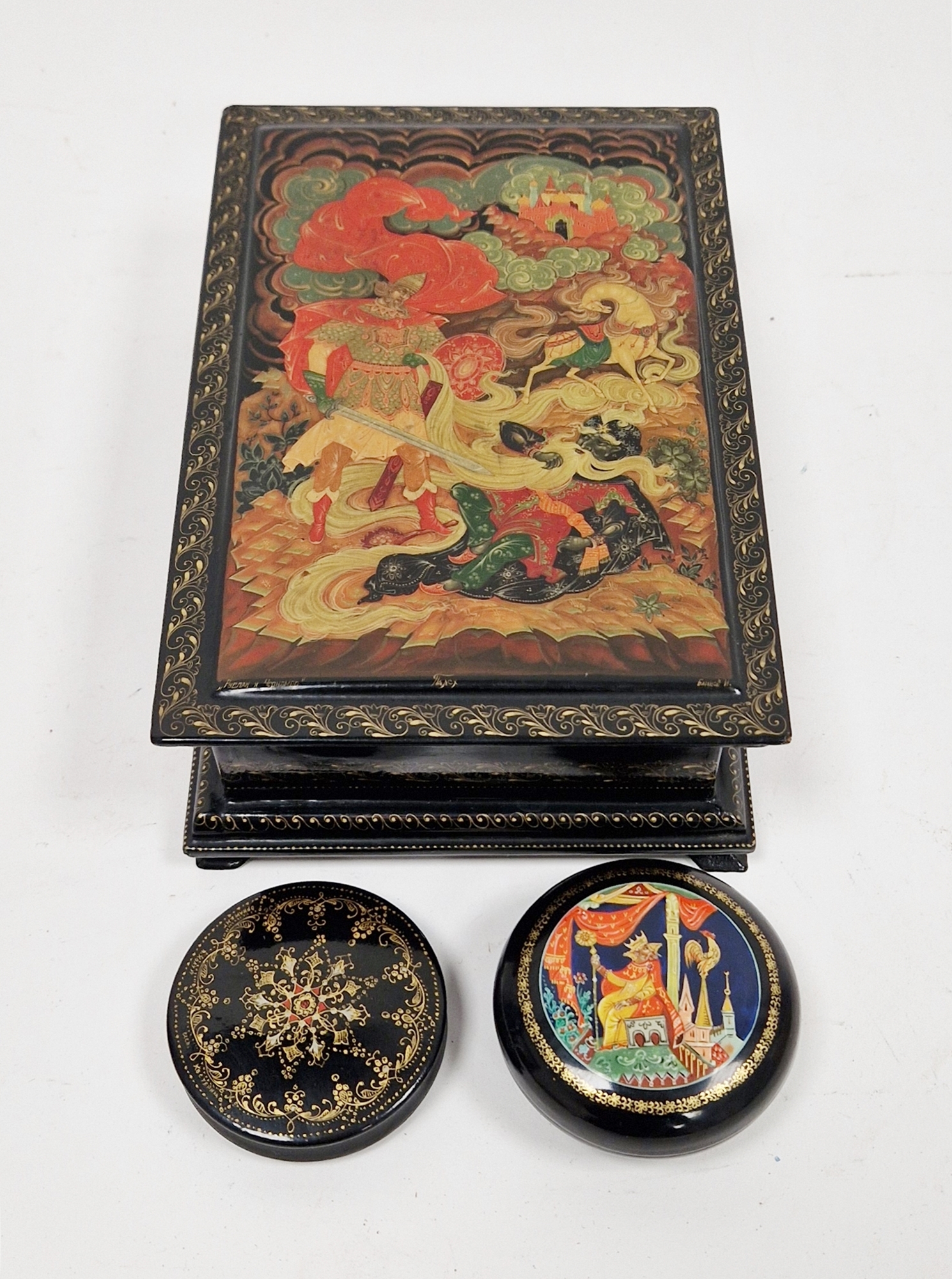 Group of painted Russian lacquer boxes comprising a hinged rectangular example decorated with a