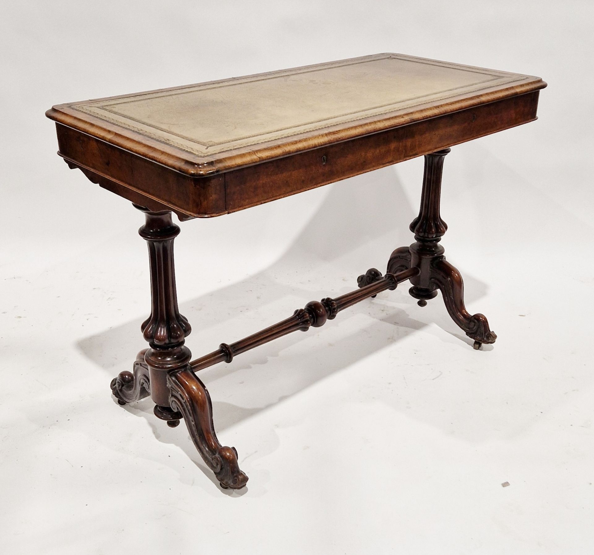 Victorian figured walnut library table with gilt tooled leather top and two drawers to the front,