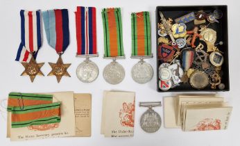Collection of military medals and badges including three WWII Defence medals, a George VI Star, a