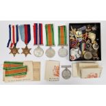 Collection of military medals and badges including three WWII Defence medals, a George VI Star, a