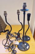 Four contemporary black metal table lamps, comprising: a pair on splayed tripod bases, one on