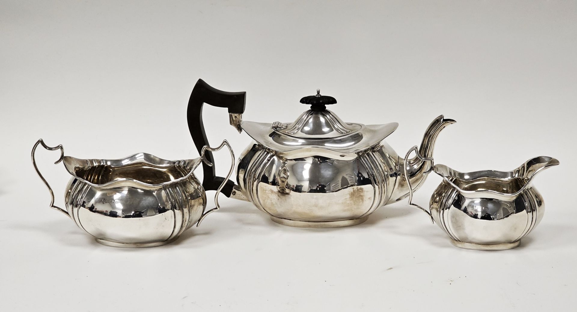 George V three-piece silver teaset comprising teapot, twin-handled sugar bowl and milk jug,