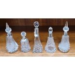 Four Victorian and Edwardian silvered collared cut-glass perfume bottles and a white metal mounted