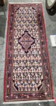 Iranian cream ground wool runner with central geometric medallion on floral and stylised bird field,