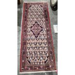 Iranian cream ground wool runner with central geometric medallion on floral and stylised bird field,