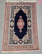 Eastern blue ground silk rug, possibly Iraq, the central floral medallion on plain field with floral