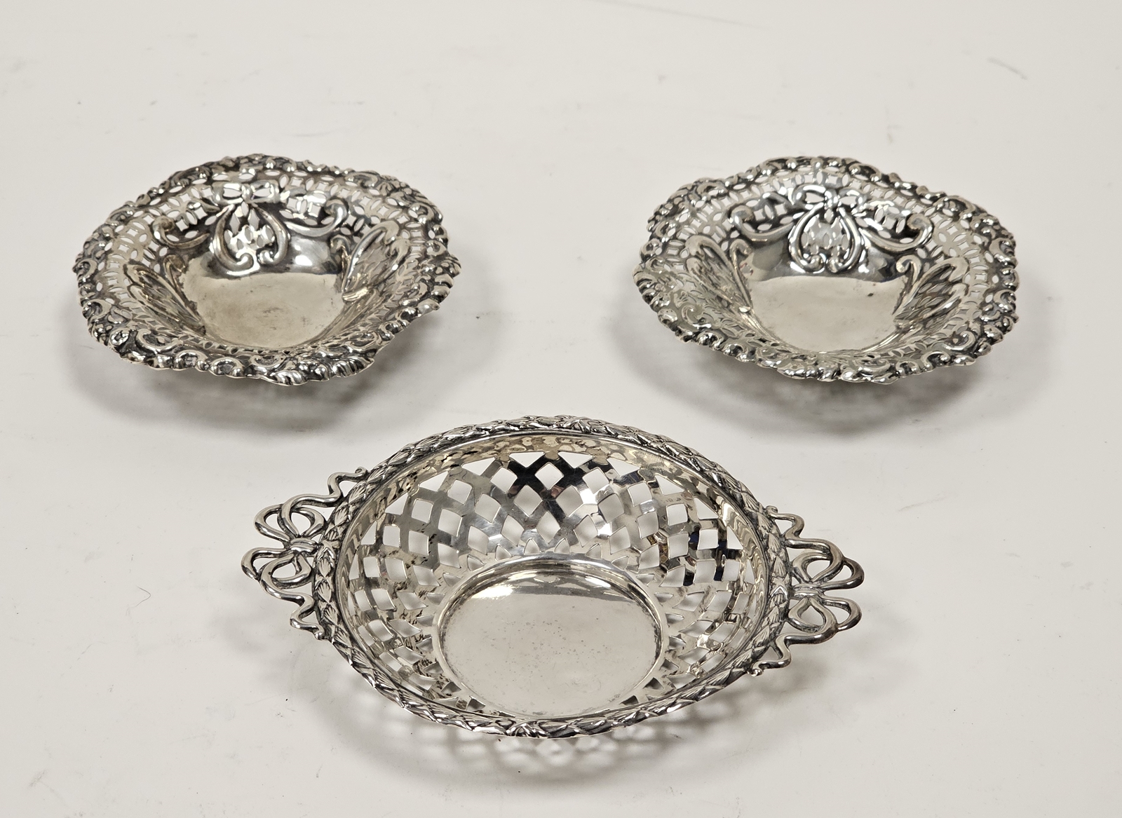 A pair of Victorian silver pierced circular bonbon dishes, embossed with heart motifs, raised on - Image 2 of 4