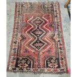 Eastern red ground rug with central three stepped lozenge medallion on geometric shape field to