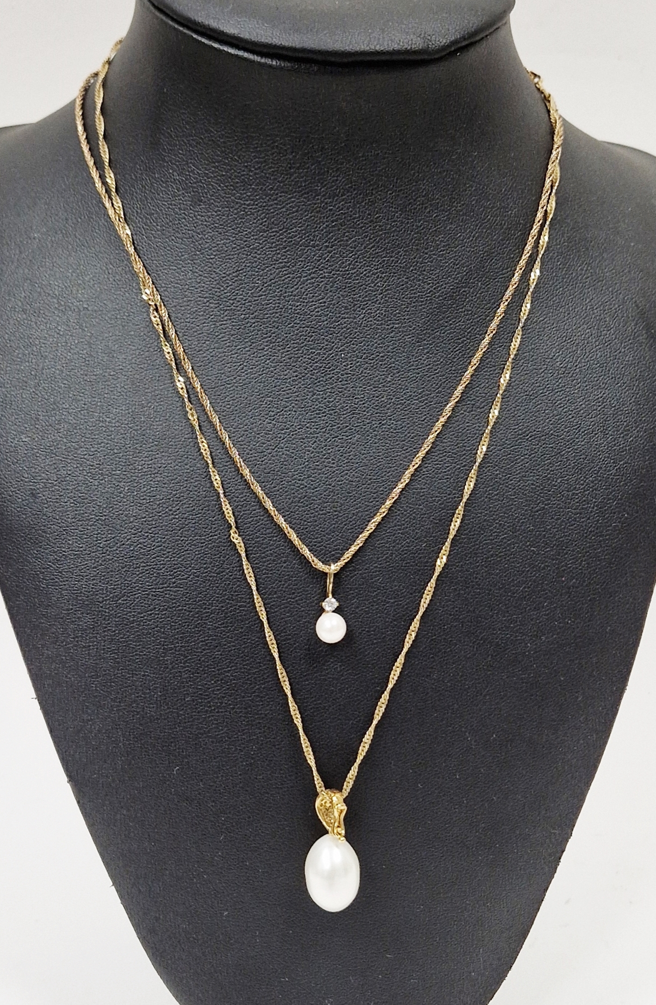 Gold and white stone pendant with oval pearl drop, small stones to the loop, on 9ct gold fancy chain