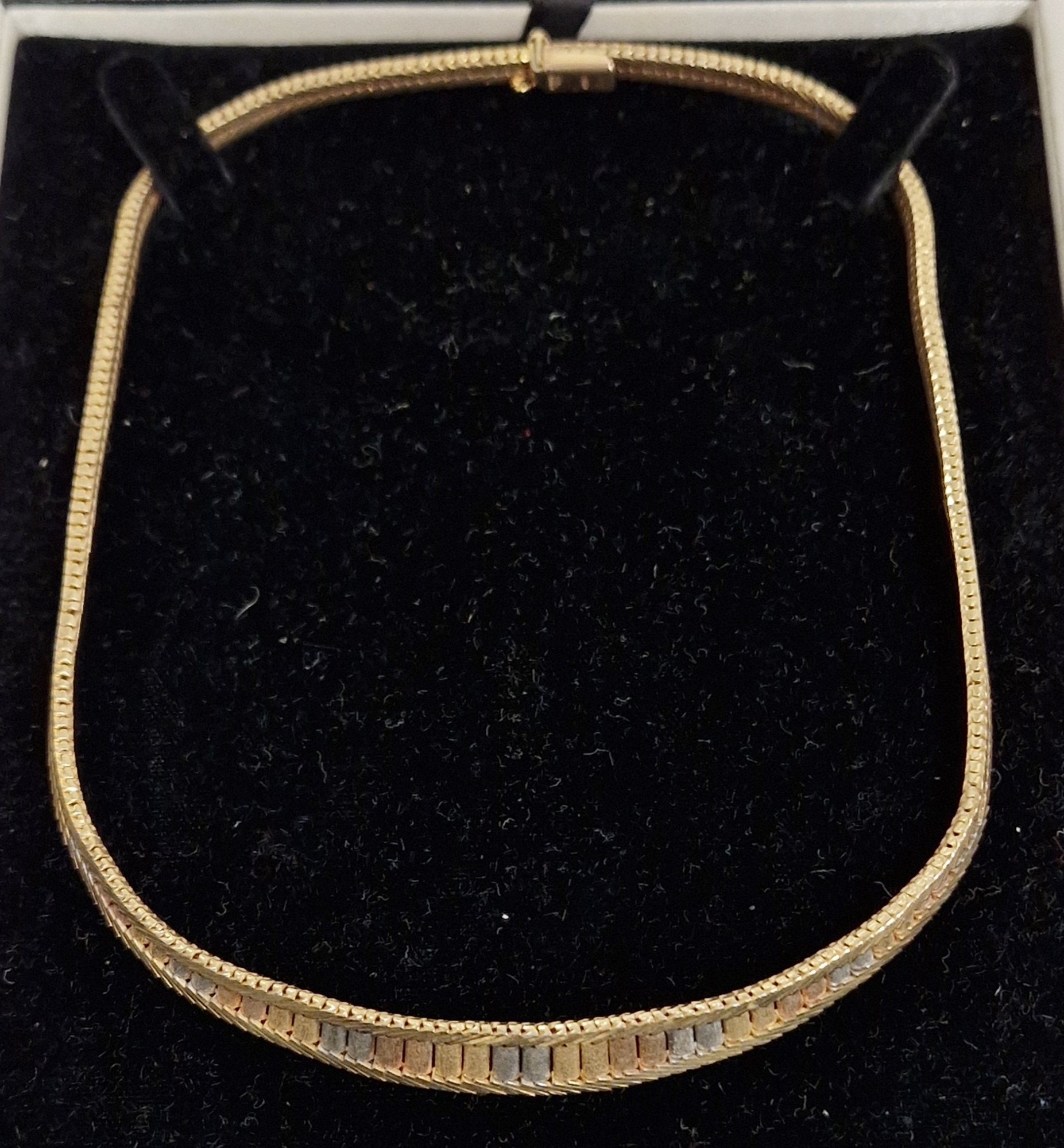 9ct three-colour gold collarette necklace having matt graduated panels within herringbone borders,