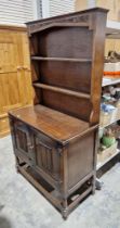 Mid 20th century oak kitchen dresser with two tier plate rack, over a two-door cupboard, 176cm