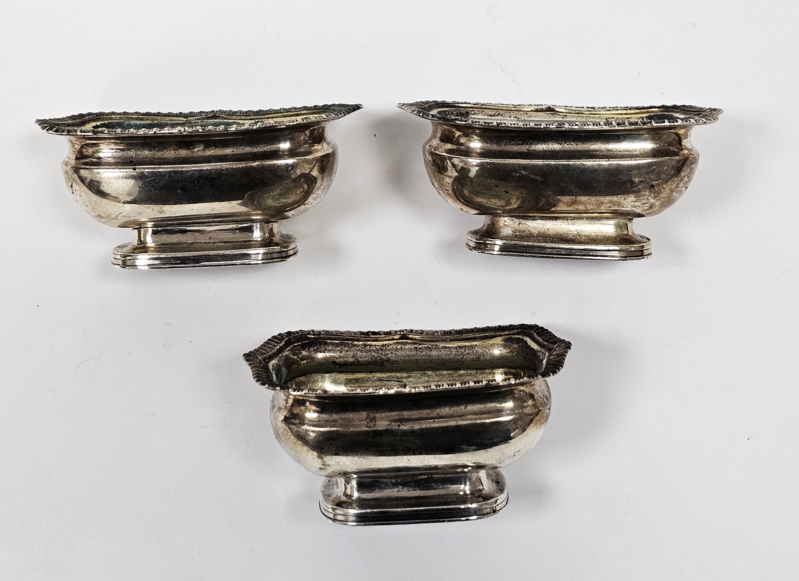Set of three George III silver salts, each rectangular with serpentine gadrooned everted rim on